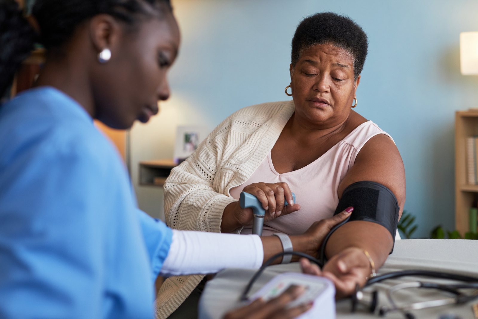 A nurse checks a patient’s blood pressure during a routine check-up